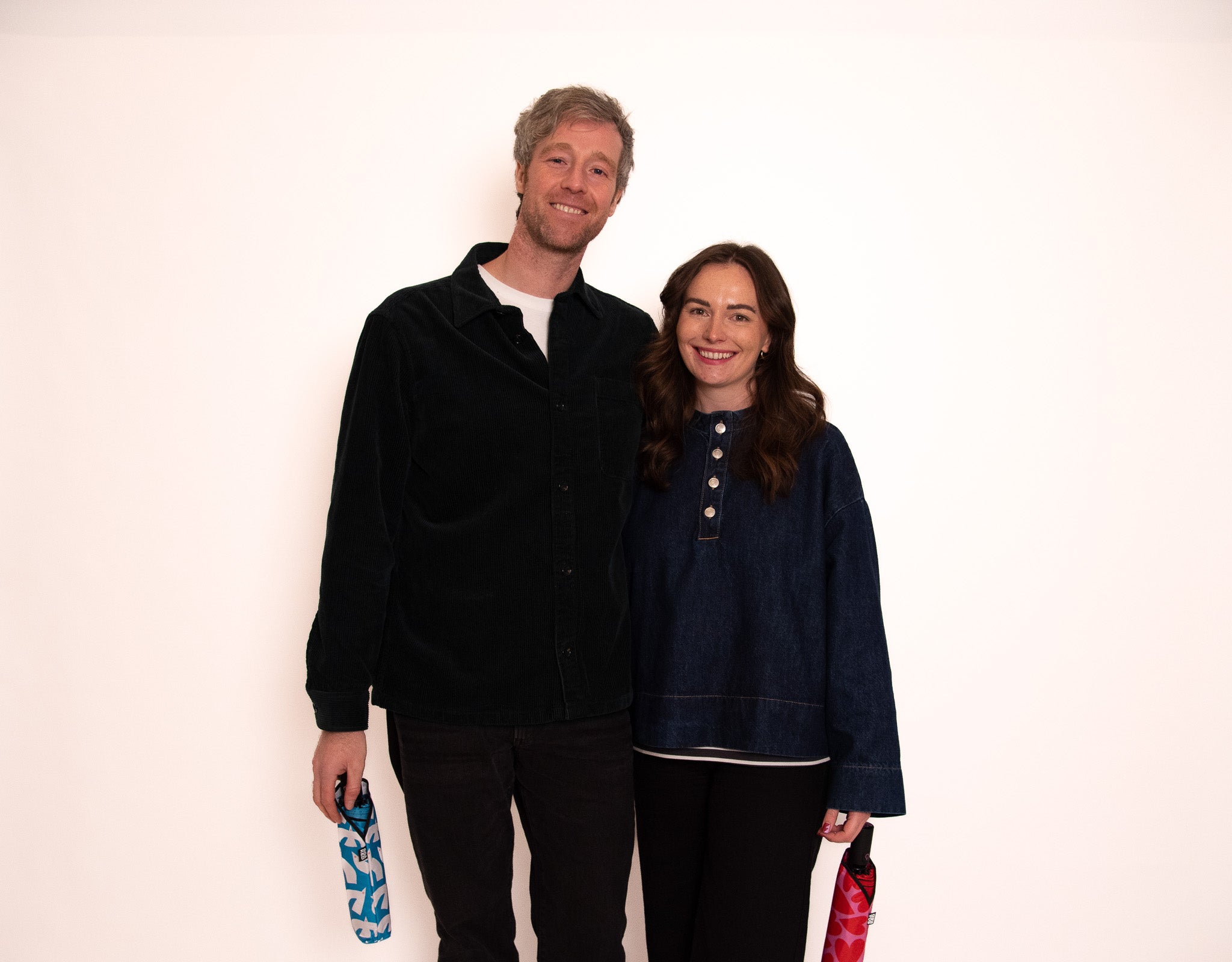 SOAKED co-founders Meg and David from Manchester holding a sustainable umbrella, representing brand origin and mission in rainy UK weather