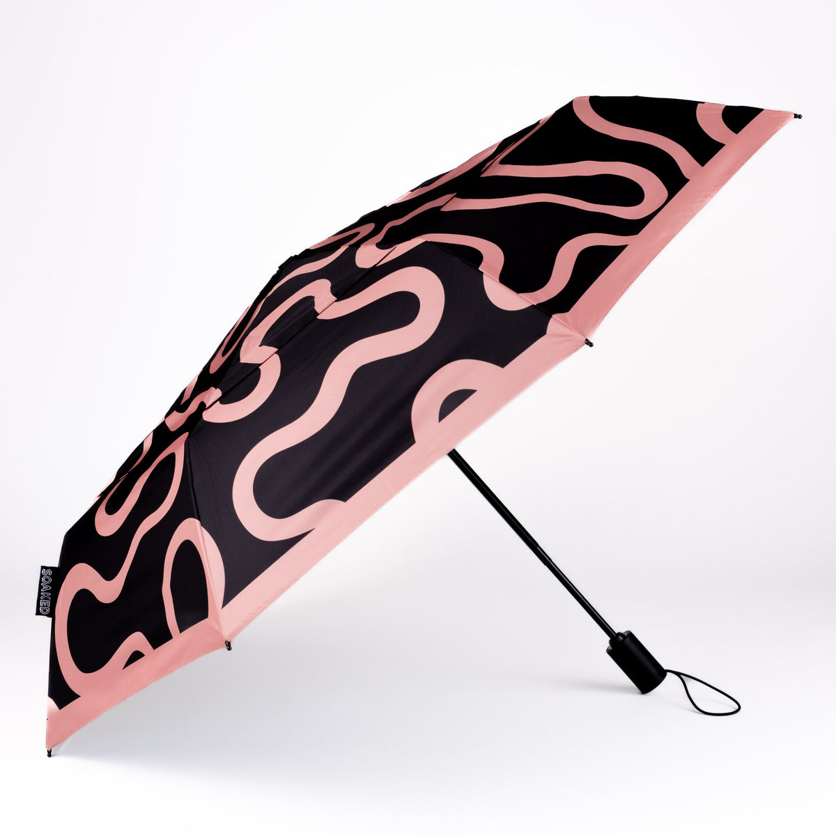 Side view of the vented, wind-resistant canopy on the SOAKED Doodle black and peach swirl umbrella
