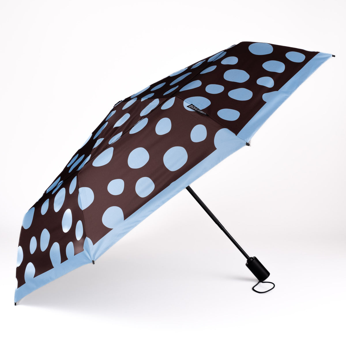 Side view of the vented, wind-resistant canopy on the SOAKED Polka brown and sky blue polka dot umbrella