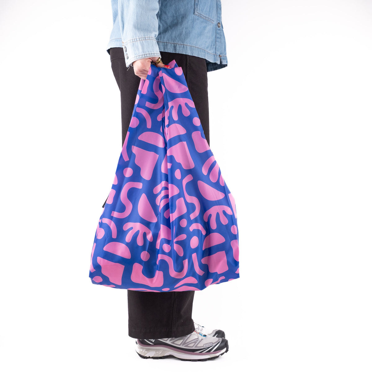 Person standing side-on with the SOAKED Bits and Bobs purple and blue tote bag