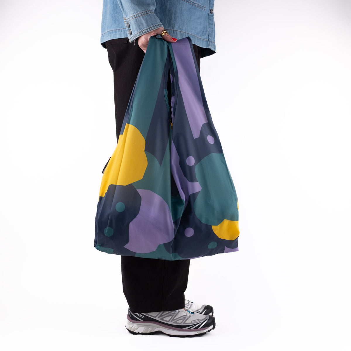 Person standing side-on with the SOAKED Cloudburst cloud and floral tote bag