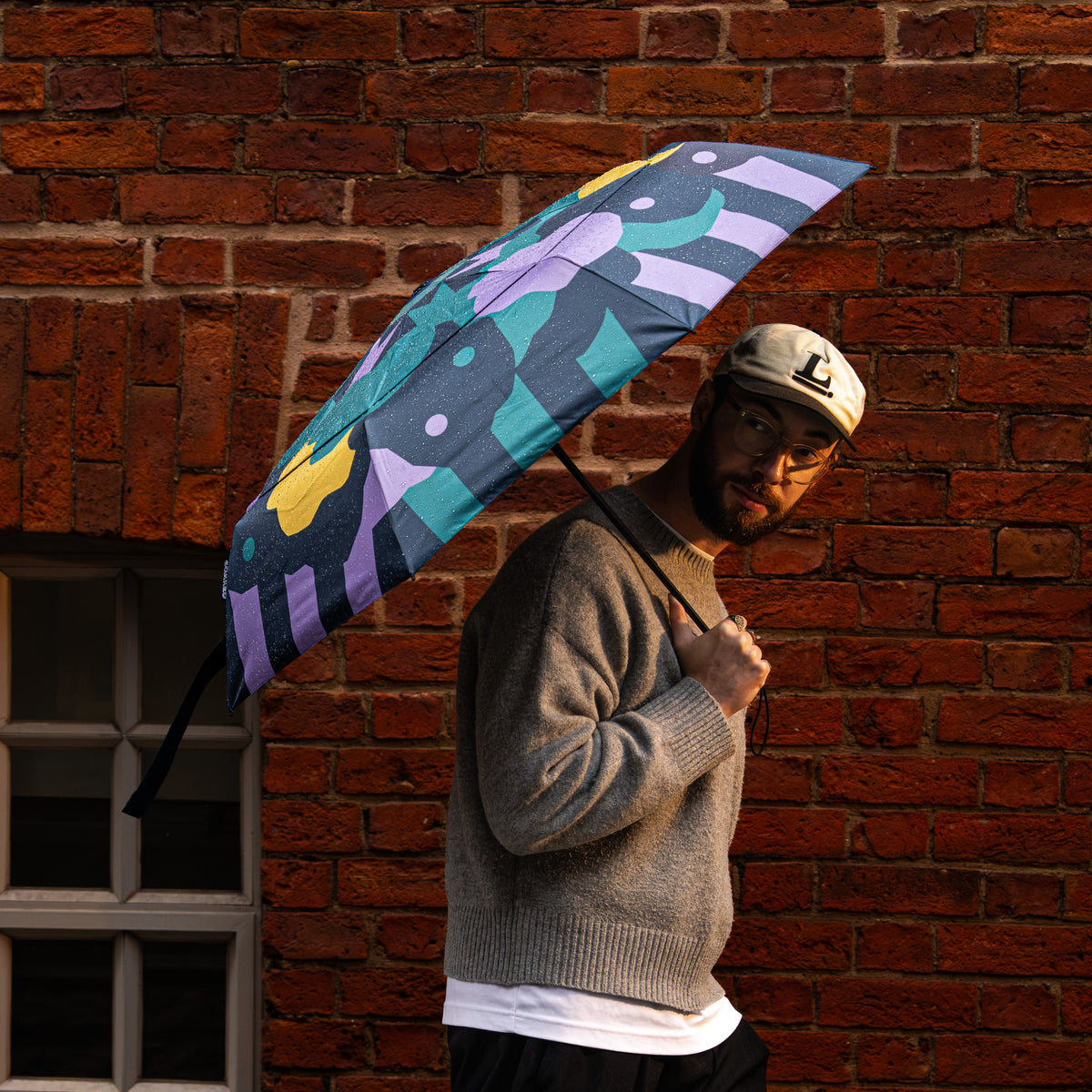 Model holding the SOAKED Cloudburst cloud and floral umbrella overhead in the rain, waist-up