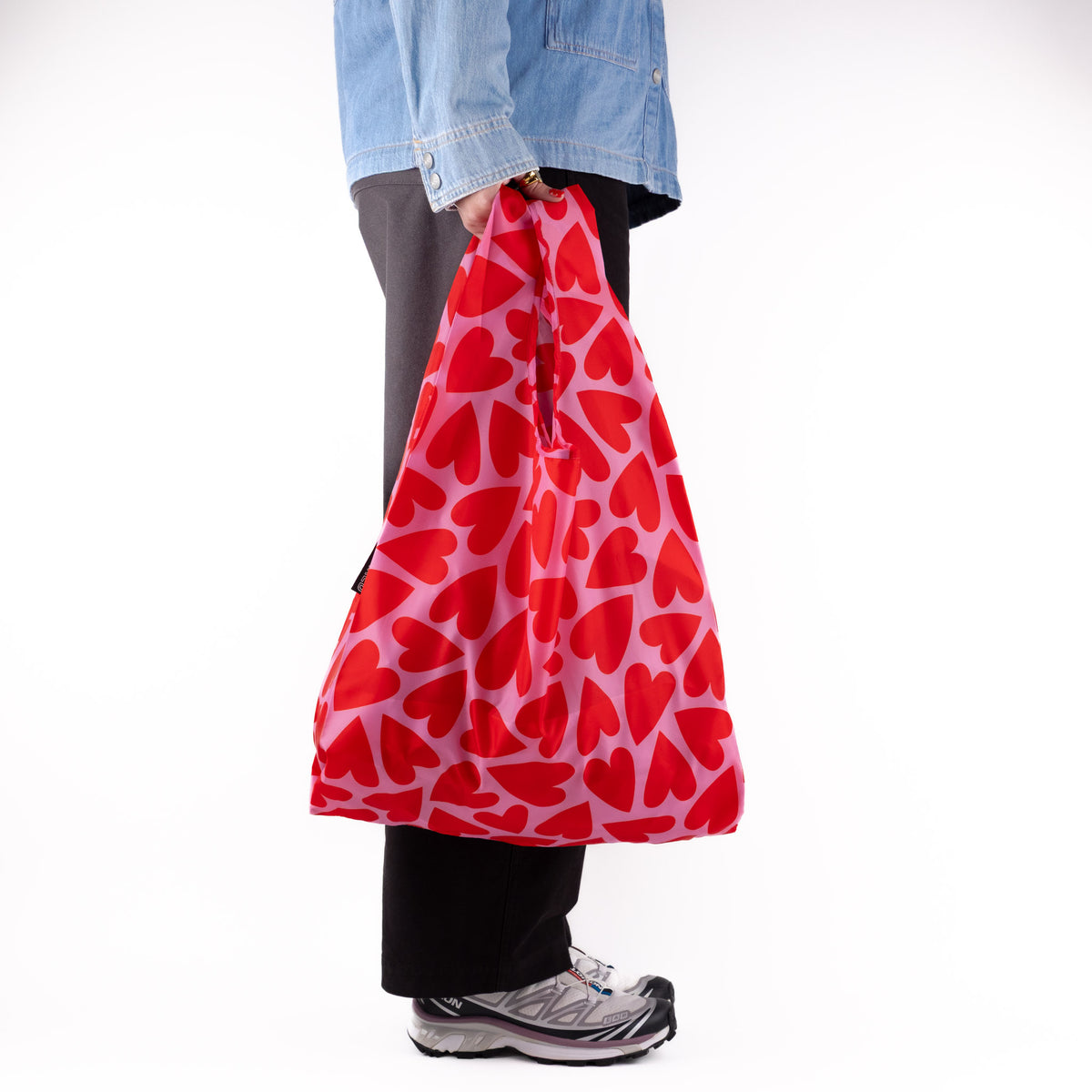 Person standing side-on with the SOAKED Love Bug heart print tote bag