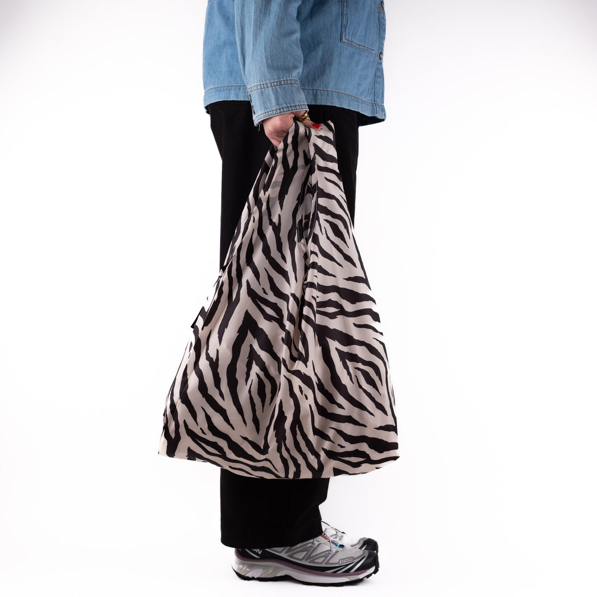 Person standing side-on with the SOAKED Safari zebra print tote bag